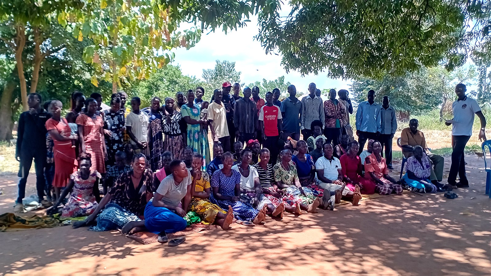 Community members gather under the trees for an intergenerational dialogue session in Atiak